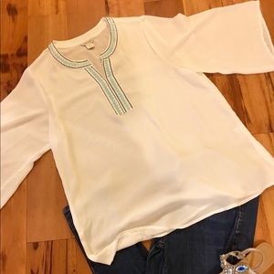 White blouse with navy and teal detail
